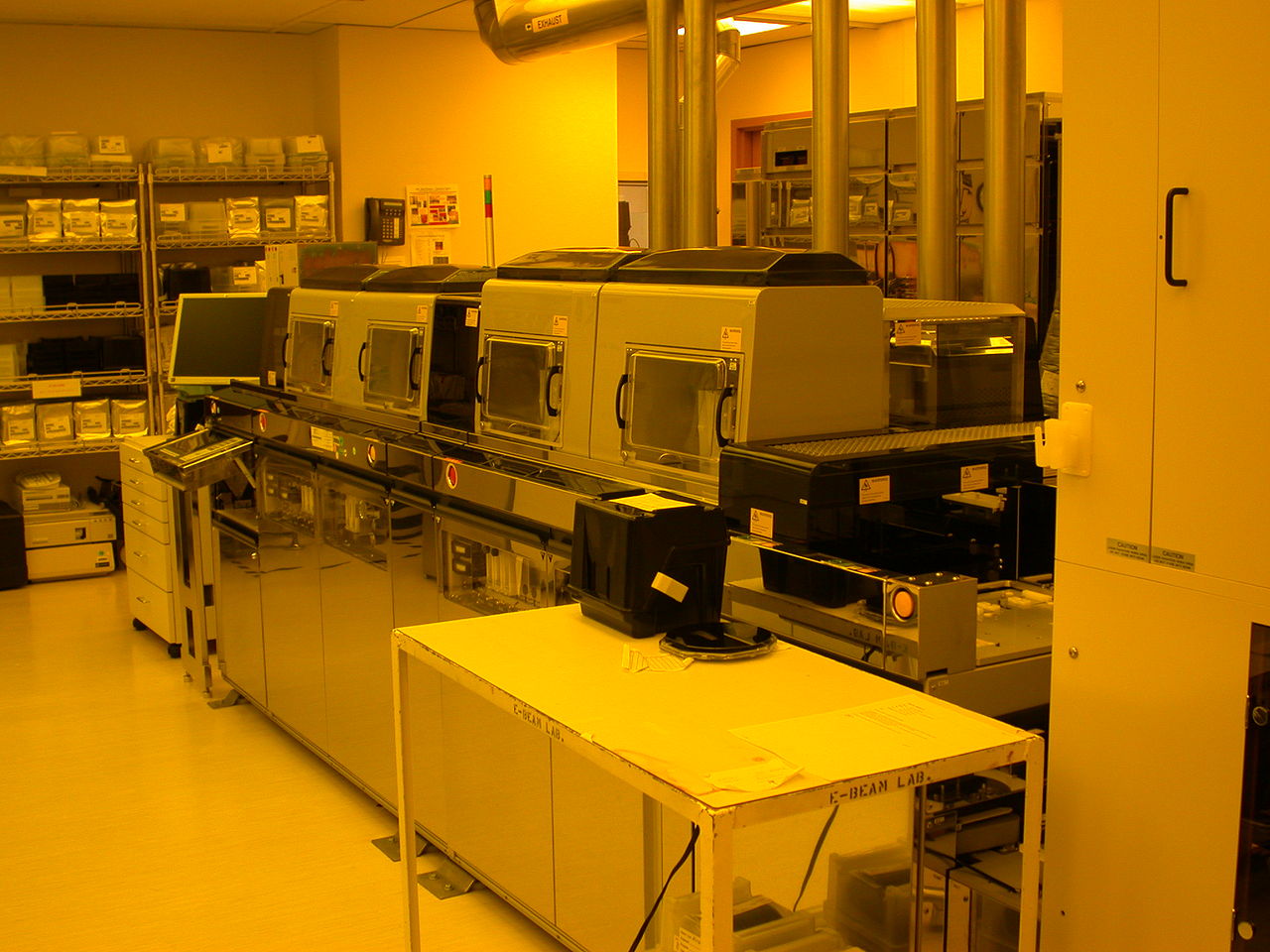A photolithography wafer-track system in a yellow-lit semiconductor cleanroom